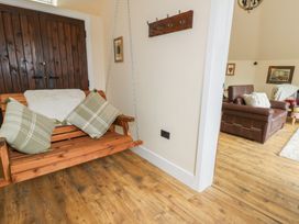 A living room with a swing and cushions at Yr Awen in Lampeter