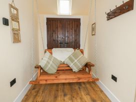 A swing with cushions in an indoor area at Yr Awen in Lampeter