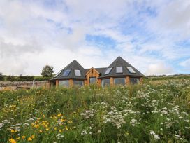 A house surrounded by flowers and grass at Yr Awen in Lampeter