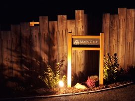 A sign for Maes Celt illuminated at night near Lampeter