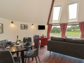 A living room with a dining table and a sofa at Y Cwlwm in Lampeter