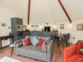 A living room with a kitchen unit and dining area at Y Cwlwm in Lampeter