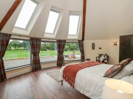 A bedroom with a bed and large windows at Y Cwlwm in Lampeter