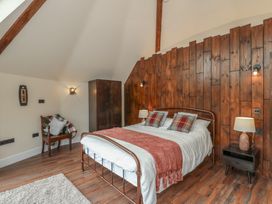 A bedroom with a bed and wooden wall at Y Cwlwm in Lampeter