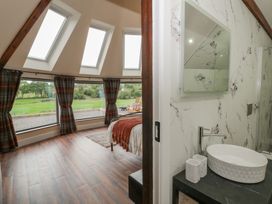 A bedroom with a bed and a wash basin at Y Cwlwm in Lampeter