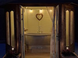 A bathroom with a bathtub and decorative elements at Y Cwlwm - The Celtic Knot near Lampeter