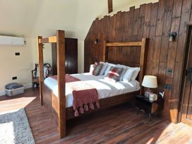 A bedroom with a wooden bed and nightstand at Y Cwlwm - The Celtic Knot near Lampeter