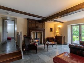 A living room with a fireplace and armchair at Souterstead Torver near Coniston