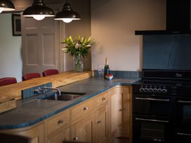 A kitchen with a sink, countertop, oven and a flower vase at Souterstead in Torver near Coniston