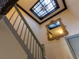 A staircase with a stained glass window and mirror at Souterstead in Torver near Coniston