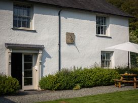 A house facade with a door, windows, and a table with an umbrella at Souterstead in Torver near Coniston