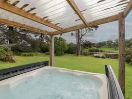 A hot tub under a wooden structure in an outdoor area at Souterstead in Torver near Coniston