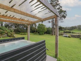 A hot tub under a wooden pergola in a garden at Souterstead Torver near Coniston