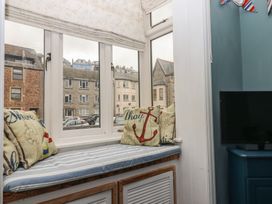 A living room with a window seat and TV at Home by the Harbour in Dartmouth