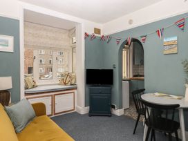 A living room with a television and dining table at Home by the Harbour in Dartmouth