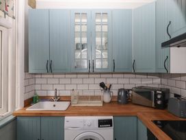 A kitchen with cabinets, sink, washing machine, and kitchen appliances at Home by the Harbour in Dartmouth