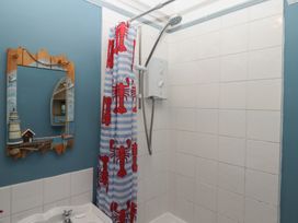 A bathroom with a shower and mirror at Home by the Harbour Dartmouth