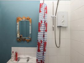 A shower with lobster patterned curtain and sink at Home by the Harbour in Dartmouth