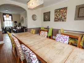 A dining room with a large table and colorful chairs at 9 The Esplanade