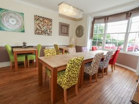 A dining room with a large table and colorful chairs at 9 The Esplanade