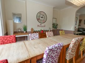 A dining room with a large table and colorful chairs at 9 The Esplanade
