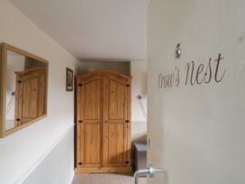 A hallway with a wooden wardrobe and mirror at Crow's Nest