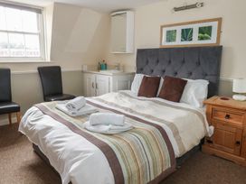 A bedroom with a bed and chairs at 9 The Esplanade