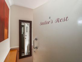 An entryway with a door, mirror, and table at Sailor's Rest