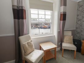 A seating area with chairs and a table overlooking the water at 9 The Esplanade