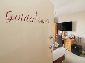 A bedroom with a bed and a television at Golden Sands 5