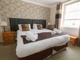 A bedroom with a bed, bedside tables, and a window at 9 The Esplanade