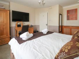 A bedroom with a bed, wardrobe, desk and television at 9 The Esplanade