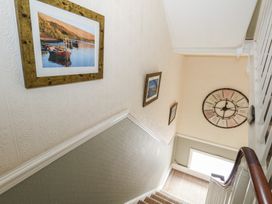 A staircase with pictures on the wall and a clock at 9 The Esplanade
