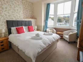 A bedroom with a bed and chairs at 9 The Esplanade