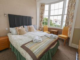 A bedroom with a bed and windows at 9 The Esplanade