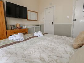 A bedroom with a bed, television, and kettle at 9 The Esplanade 