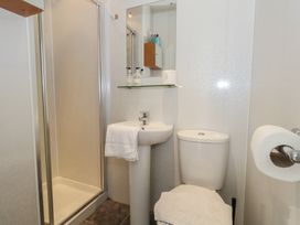 A bathroom with a shower, sink, and toilet at 9 The Esplanade