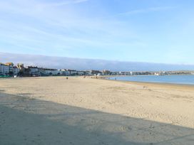A beach with sand and buildings along the shore at 9 The Esplanade