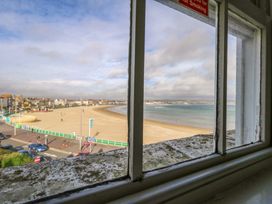 A view of the beach and sea through a window at 9 The Esplanade in Weymouth