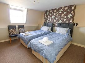 A bedroom with two beds and a window at 9 The Esplanade Weymouth