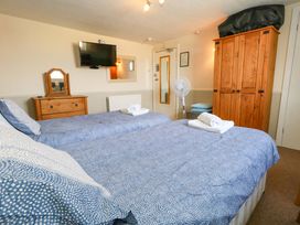 A bedroom with two beds and a wardrobe at 9 The Esplanade in Weymouth