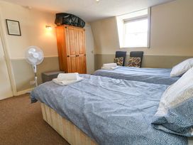 A bedroom with two beds and a wardrobe at 9 The Esplanade in Weymouth