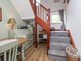 A dining area with a staircase and lamp at Ocean Cottage Bude