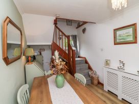 A dining room with a table and flowers at Ocean Cottage in Bude