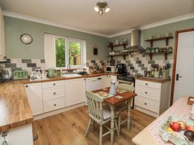 A kitchen with cabinets and a table at Ocean Cottage in Bude