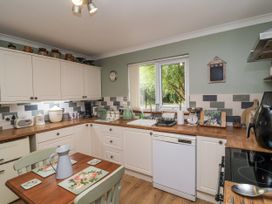 A kitchen with cabinets and appliances at Ocean Cottage in Bude