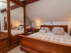 A bedroom with a bed and mirror at Ocean Cottage in Bude