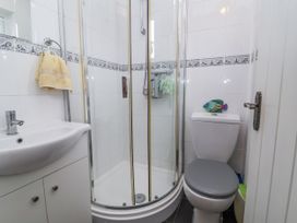 A bathroom with a shower, toilet, and sink at Ocean Cottage in Bude