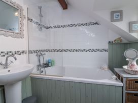 A bathroom with a bathtub and sink at Ocean Cottage in Bude
