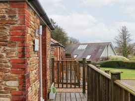 An outdoor area with a wooden deck and brick walls at 3 Keepers Cottage
